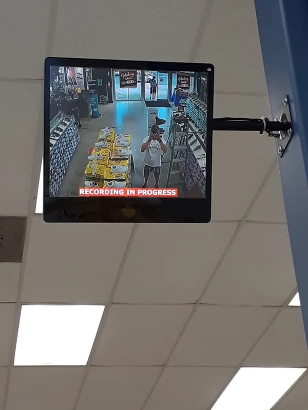 Ceiling-mounted public-view monitor recording inside a retail store